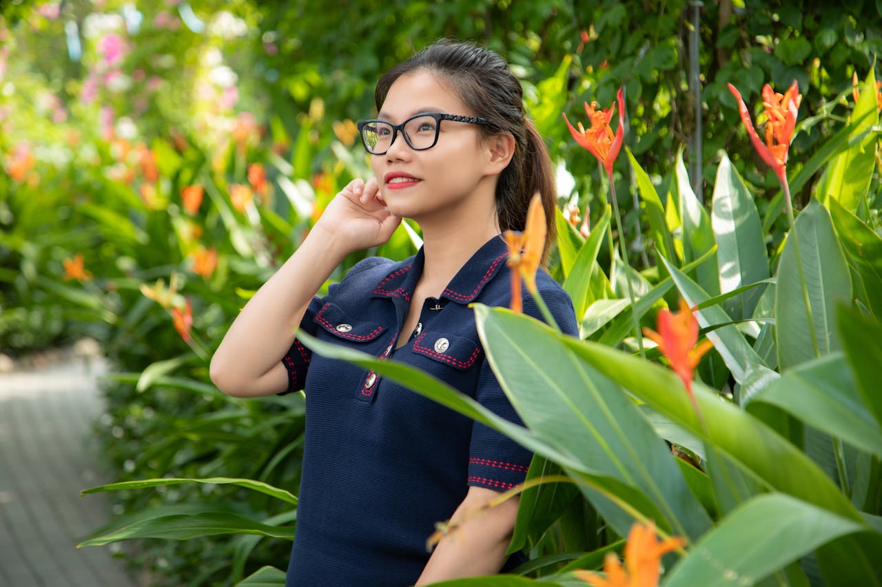 services-02 An Asian woman smiling amidst vibrant flowers in a summer garden.